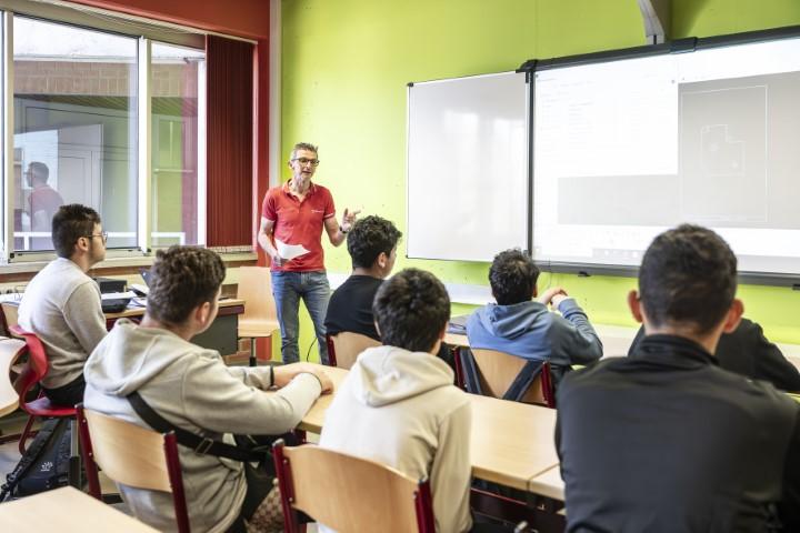Leerkracht geeft uitleg aan leerlingen in een klas van Stedelijk Lyceum Zuid.